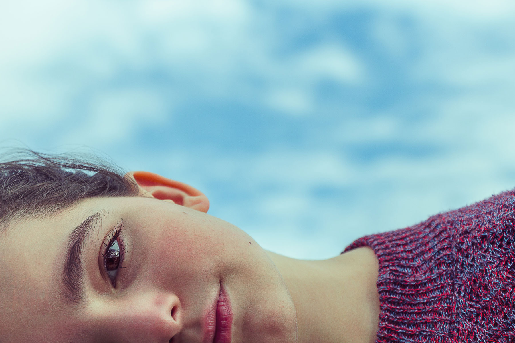 Child laying down with a blue sky behind him. Find support with your day-to-day challenges with anxiety, depression, and more with a psychological evaluation in Fort Collins, CO.